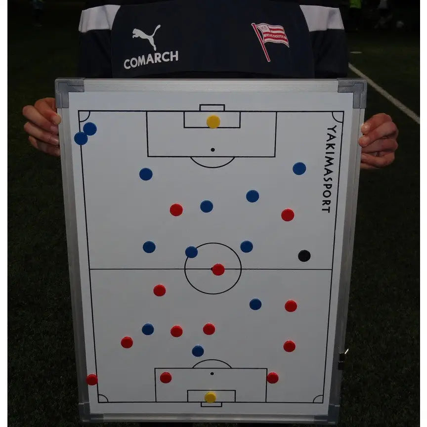 Taktisk tavle 45x60 cm for fotball, med fargede magneter plassert på banediagram, holdt av trener i treningstøy.
