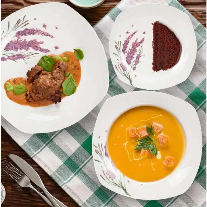 Tallerken sett i porselen, tre dekorerte tallerkener med mat, sett ovenfra på rutete duk.