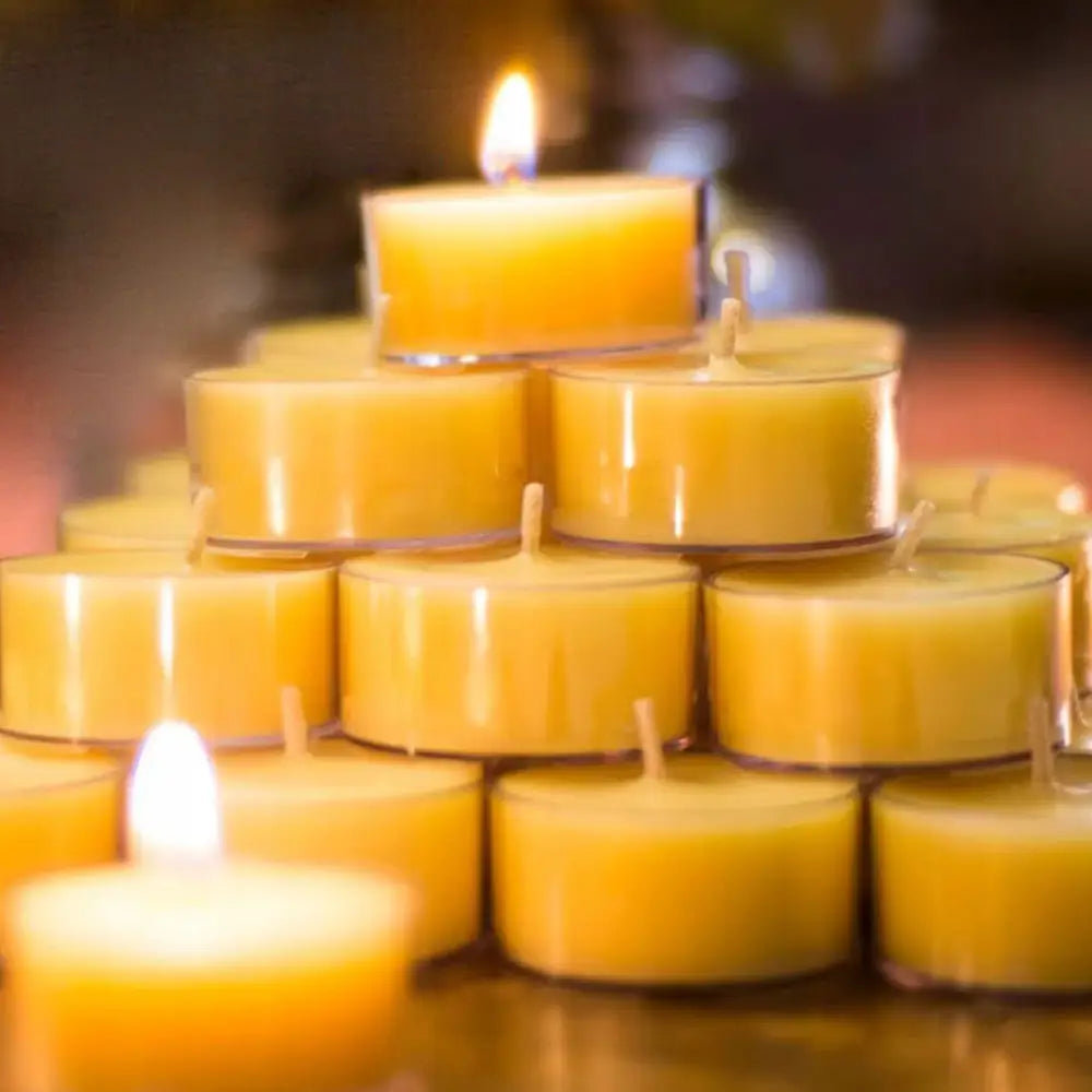 Tealight voksvarmer av bivoks, 56 gule telys i metallkopper stablet i pyramide, ett tent for varmeeffekt.