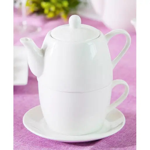 Tekanne med kopp fra Altom Design, hvit porselen sett skrått forfra på rosa duk, med tilhørende asjett.