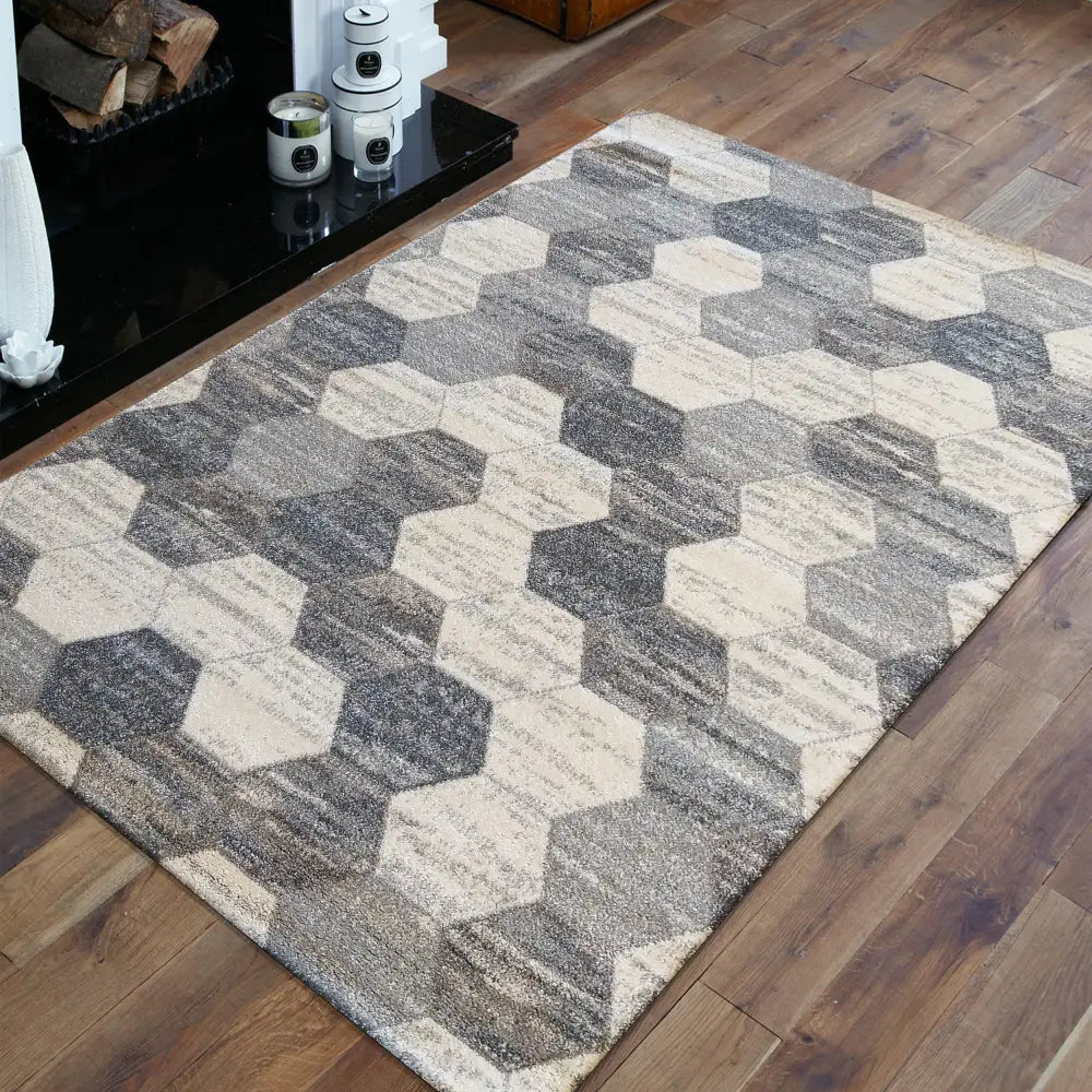 Tepe teppe 240 x 330 cm, sekskantmønster i grå og beige, skrått plassert på tregulv ved peis.
