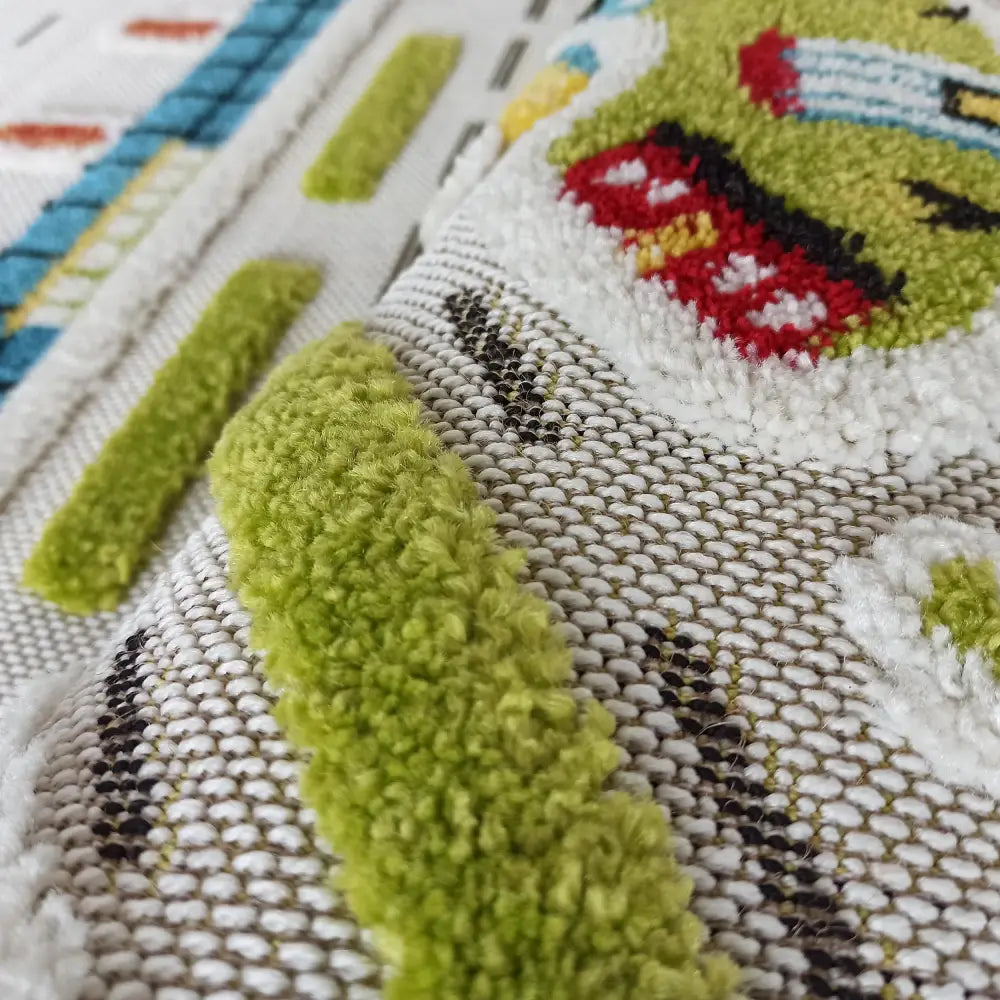 Tepe Barn teppe, nærbilde av fargerike opphøyde detaljer og tydelig tekstur på hvit vevd bakgrunn.