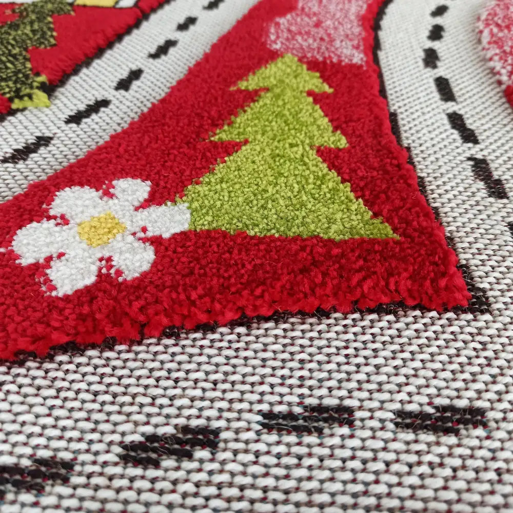 Tepe Barn Color Kids teppe, detalj av rødt felt med grønt juletre og hvit blomst på grovvevet bakgrunn.