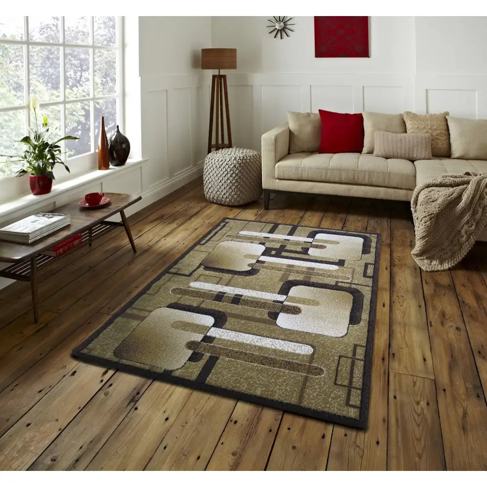 Tepe BCF Alfa 16 teppe i brunt og beige abstrakt mønster, vist på tregulv foran beige sofa i stue.