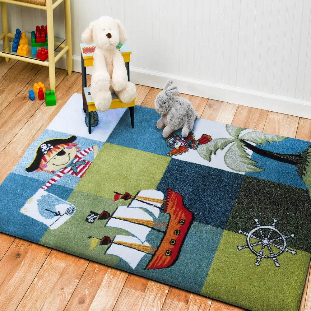 Tepe Bella 01 blå barneteppe med piratmotiv, vist skrått ovenfra med kosedyr og gul stol på teppet.