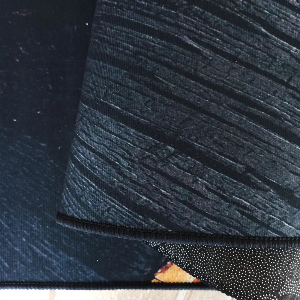 Tepe Black and Gold teppe, nærbilde av teksturert svart overflate med synlige hvite prikker på undersiden.