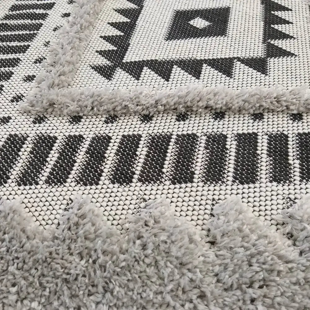 Tepe DELI 01 grått teppe, nærbilde som fremhever geometrisk mønster og variert tekstur med grå kanter.