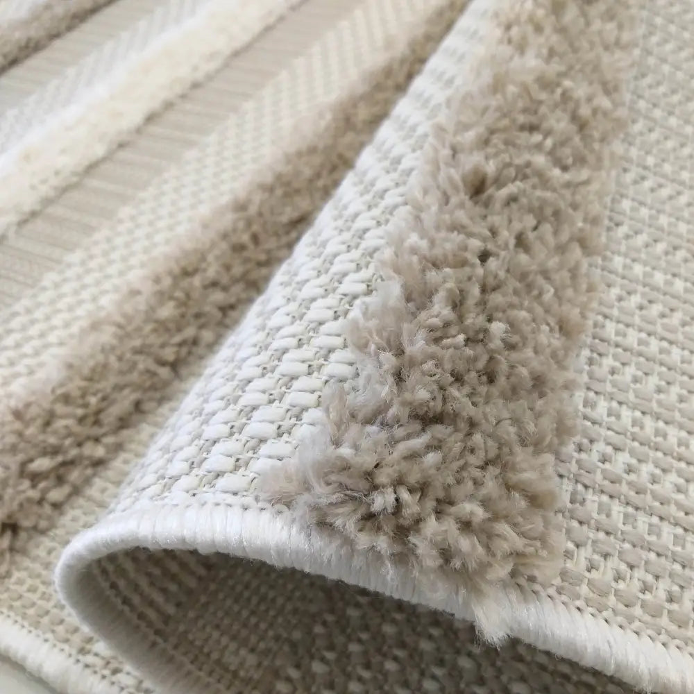 Tepe DELI 03 SAND teppe, nærbilde som fremhever vekslingen mellom flatvev og luggede striper i beige og hvitt.