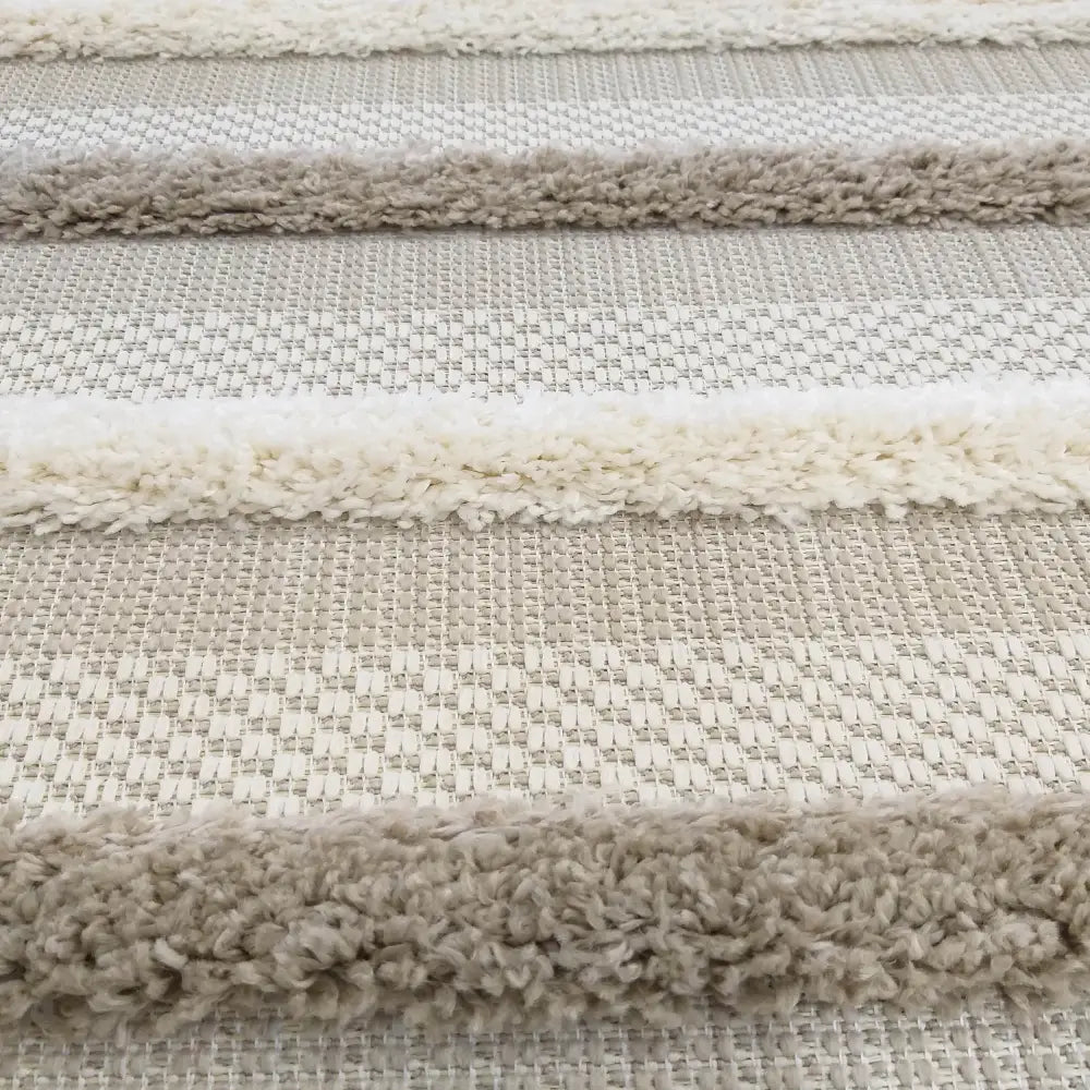 Tepe DELI 03 sandfarget teppe, detalj av kremhvite og beige striper med myk, loddent overflate.