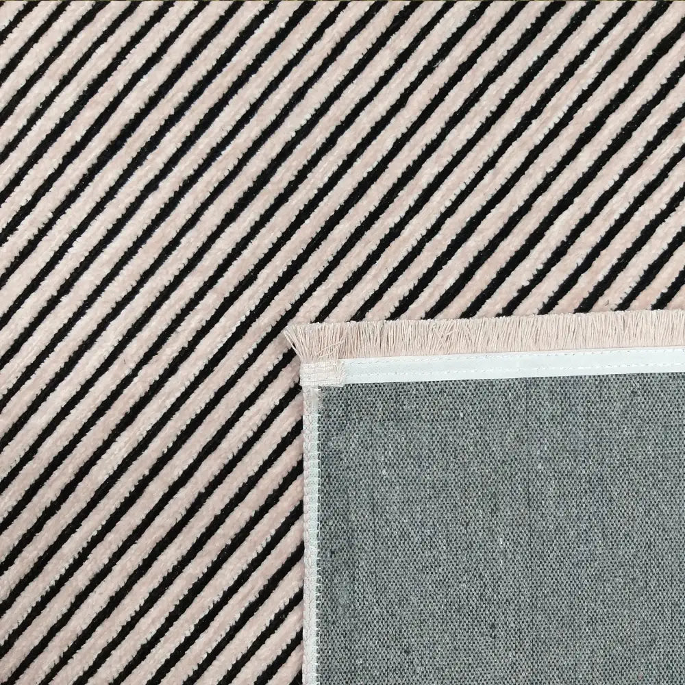Tepe Diamond teppe 80 x 300 cm, nærbilde av diagonale svarte og rosa striper med synlig grå bakside og frynser.