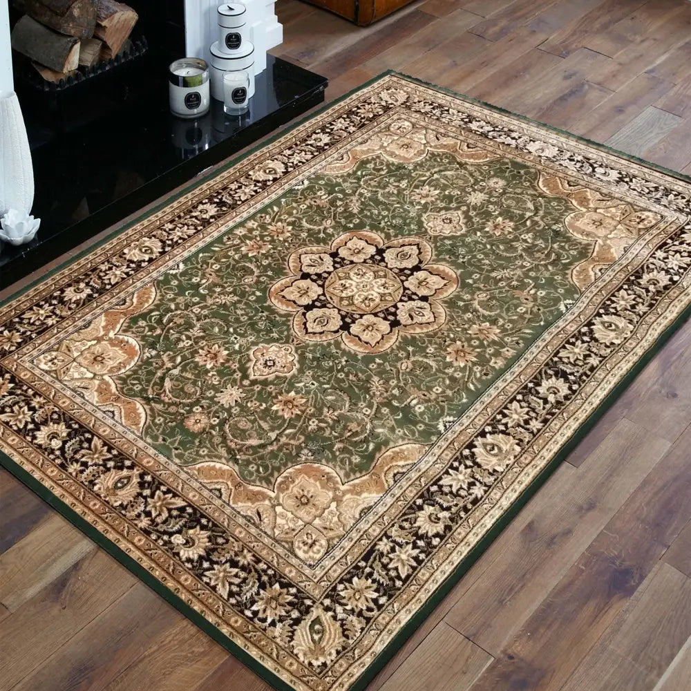 Tepe Eksklusiv 03 teppe, grønt og beige orientalsk mønster, skrå oversikt med synlige blomsterdetaljer og kant.