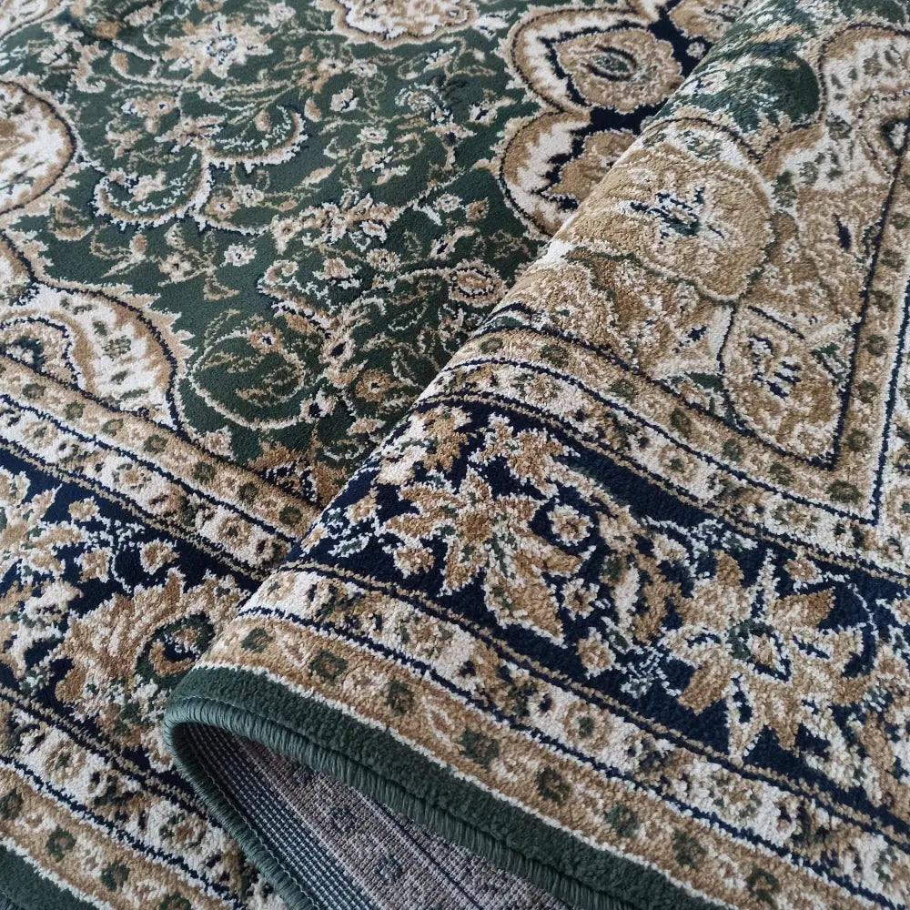 Tepe Eksklusiv teppe, nærbilde av brettet hjørne med orientalsk mønster i grønn, beige og mørkeblått.