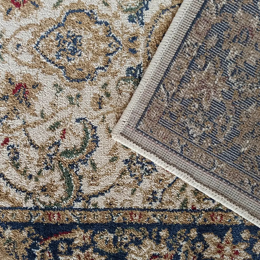 Tepe Eksklusiv 03 N, nærbilde av teppehjørne med synlig bakside, beige og fargerikt persisk mønster.