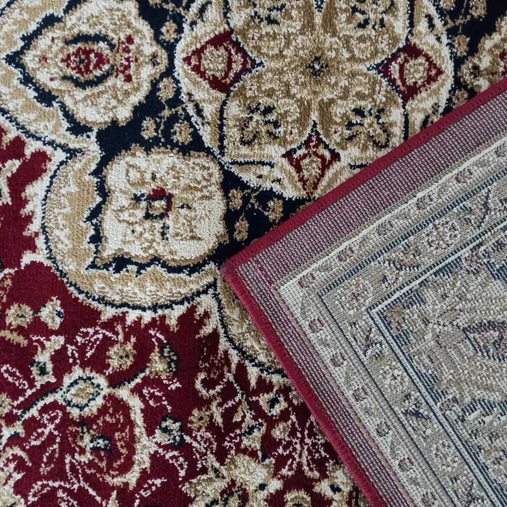 Nærbilde av Tepe Eksklusiv teppe i rødt med orientalsk mønster, detaljert kant og beige dekor.