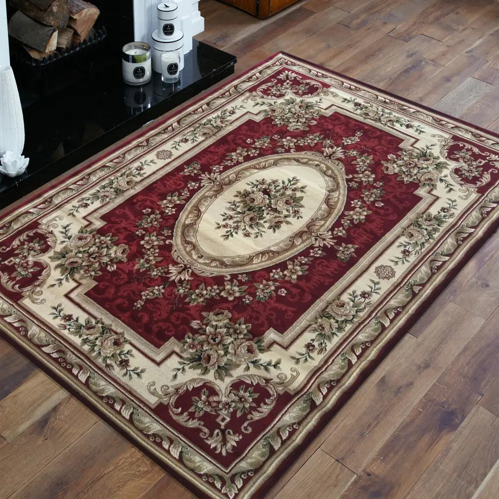 Tepe Eksklusiv 04 teppe i burgunder og beige, skrått fotografert med synlige blomster- og bladmønstre på tregulv.