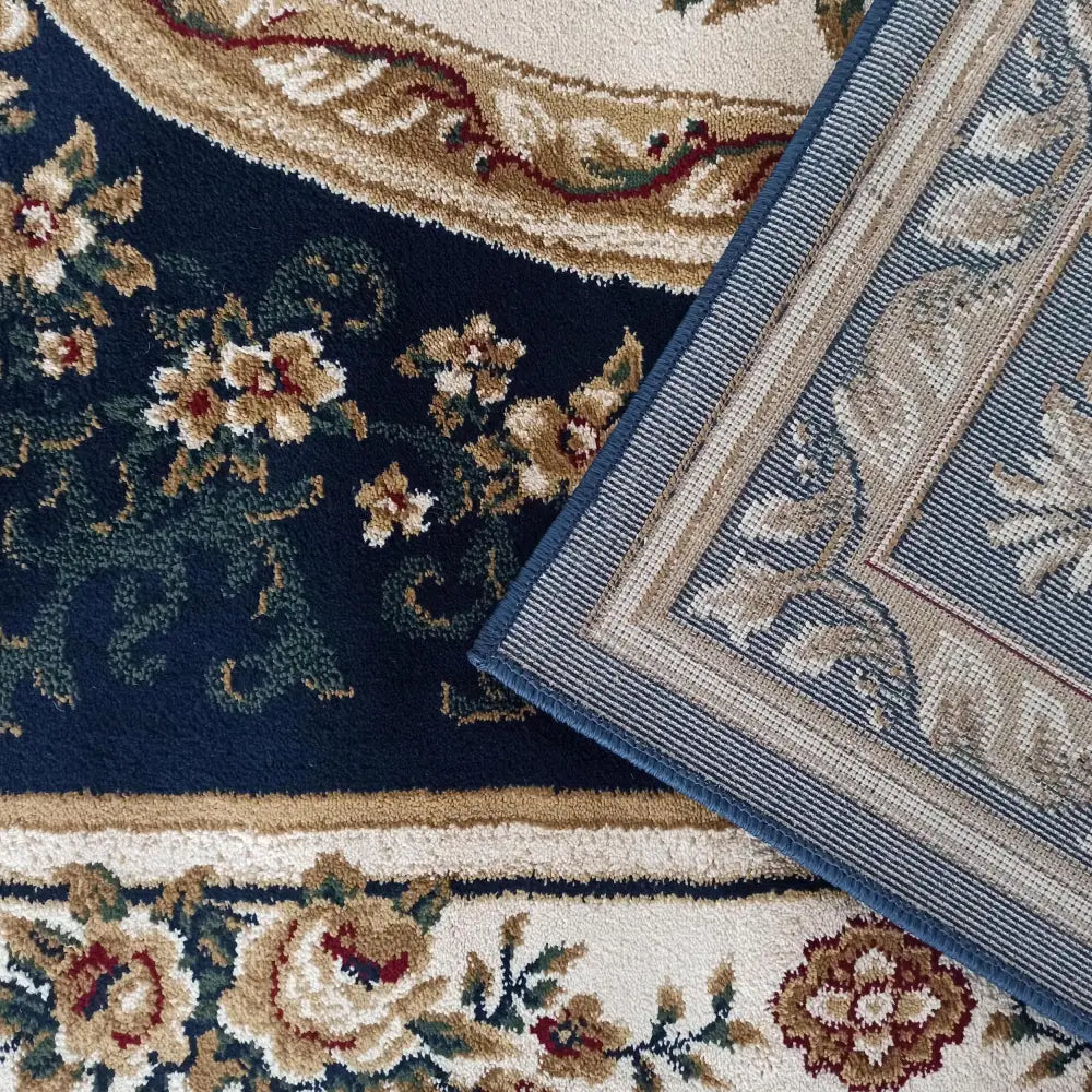 Tepe Eksklusiv 04 N teppe, detaljert utsnitt med oppbrettet hjørne som viser blå og beige bakside.