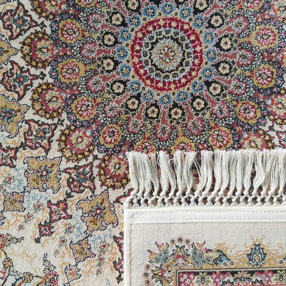 Tepe Eksklusiv Creme teppe, nærbilde av blomstermønster, hvite frynser og teppets bakside i fokus.