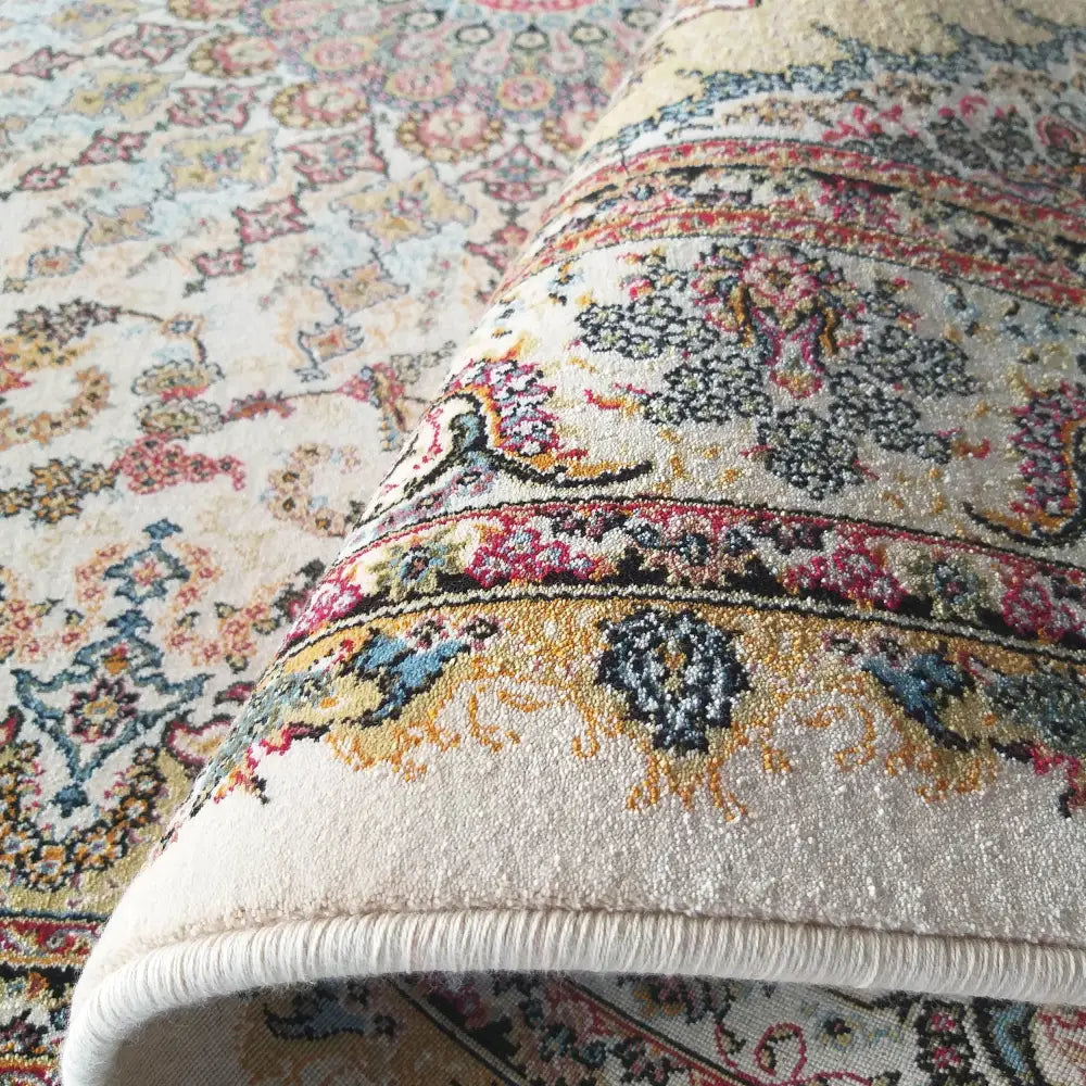 Tepe Eksklusiv Creme teppe, nærbilde av orientalsk mønster og tekstur med oppbrettet hjørneflik.