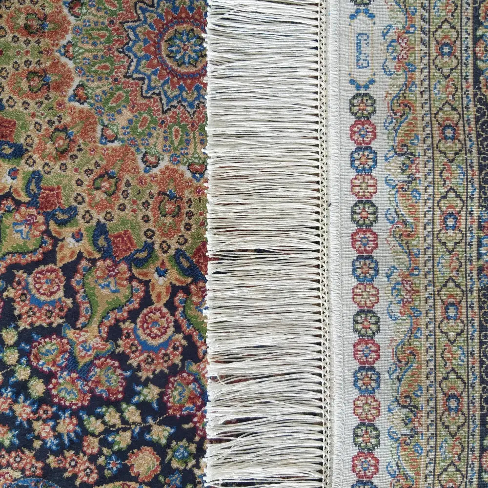 Tepe Qum Silk teppe, nærbilde av flerfarget kant med lyse frynser og detaljerte blomster- og mønsterborder.