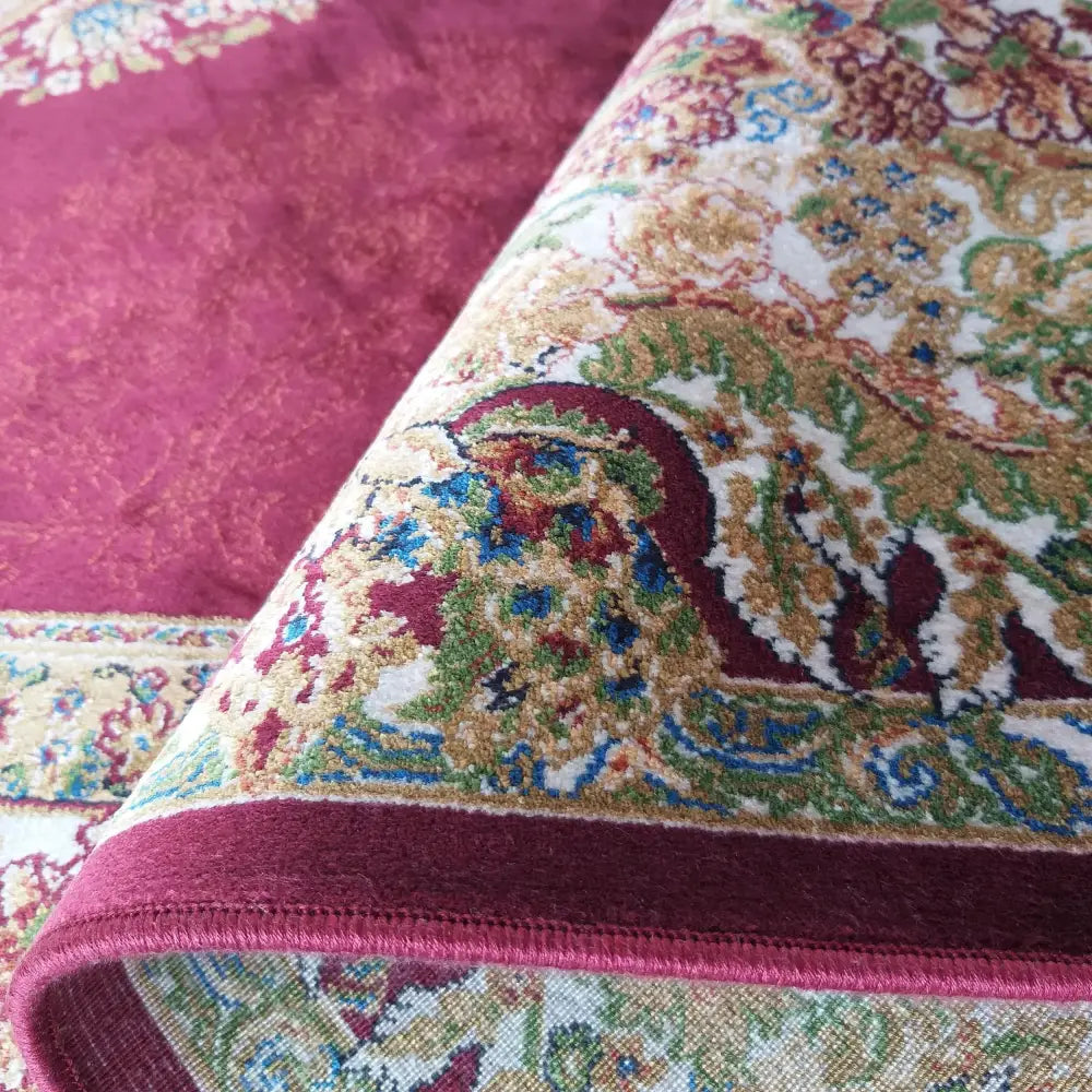 Tepe Qum Silk teppe, nærbilde av vinrødt orientalsk mønster med synlig kant og detaljert tekstur.