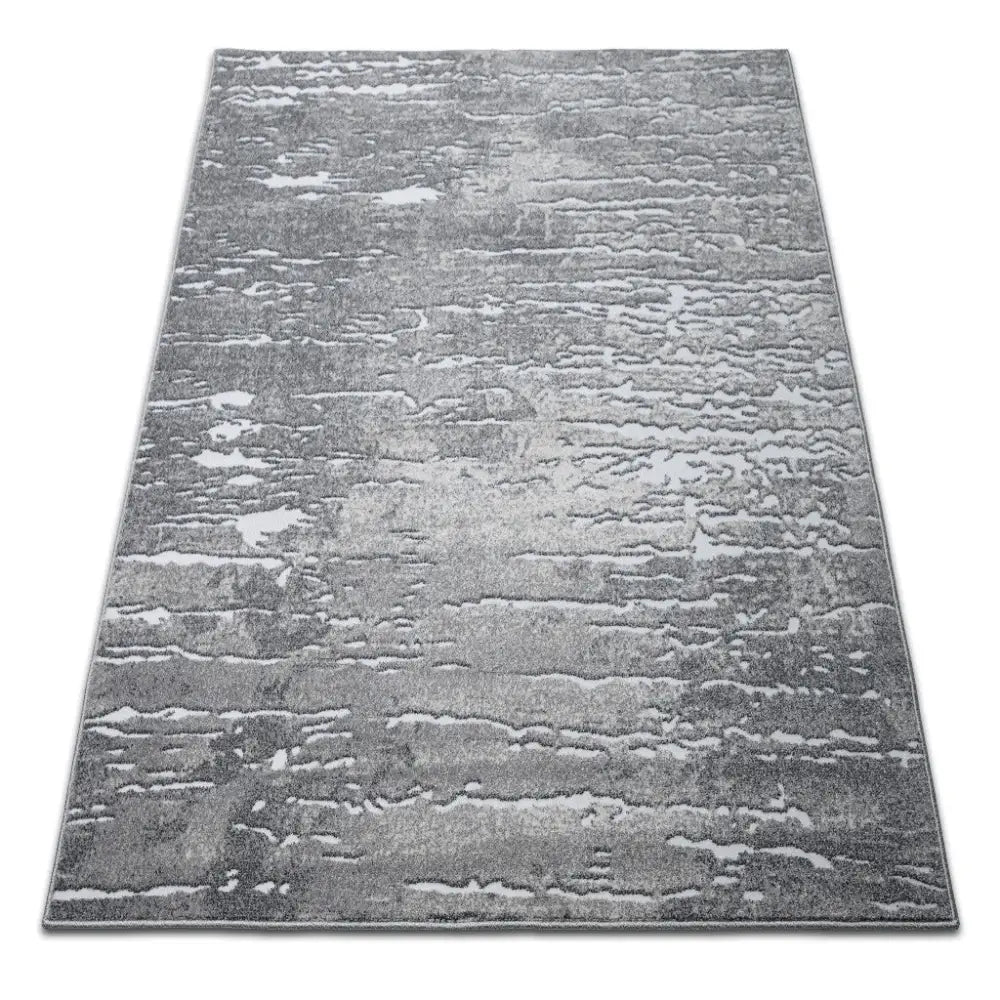 Tepe Enigma 03 teppe i gråtoner, abstrakt mønster, sett fra skrå vinkel mot hvit bakgrunn.
