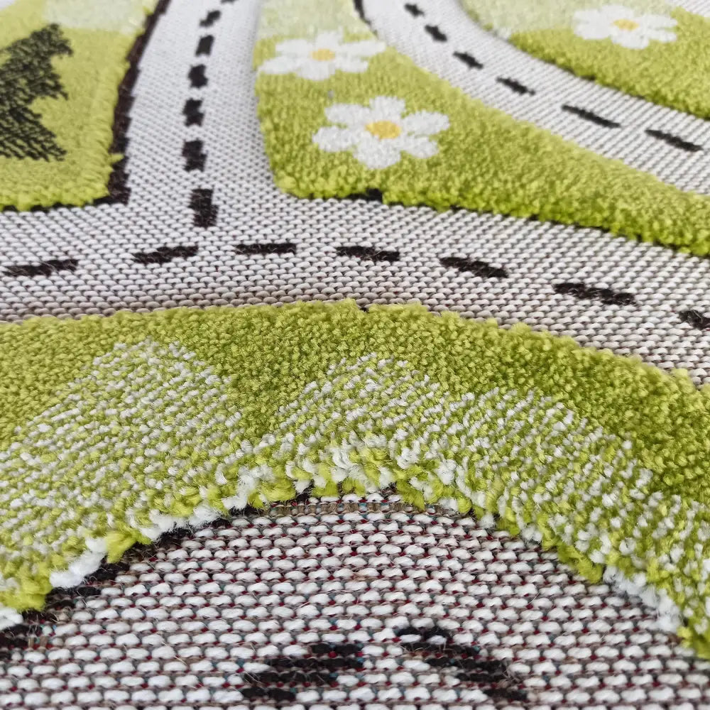 Tepe Farge Barn teppe, nærbilde av grønne og hvite fibre med blomster- og veinspirert mønster.