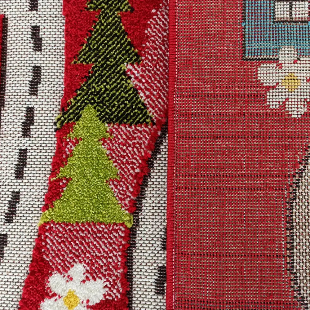 Tepe Farge Barn 02 Rød tekstil, nærbilde av grønne juletrær og hvite blomster på rød bakgrunn med rutete kant.