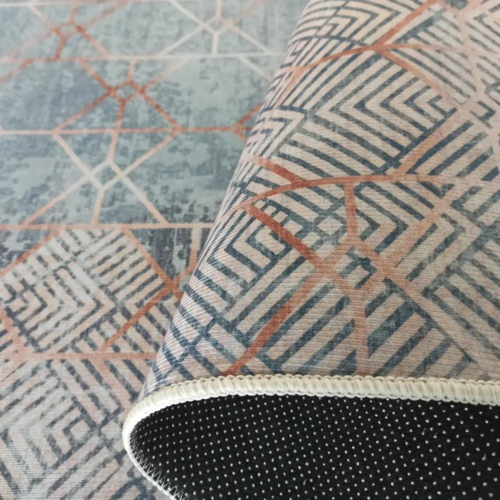 Tepe Horeca teppehjørne, brettet for å vise blått og rust mønster samt underside med antiskli-prikker.