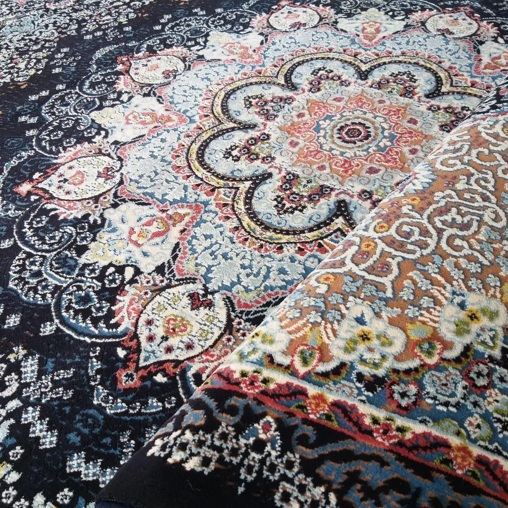 Tepe Irani LUKSUS-teppe, nærbilde av blått og rødt orientalsk mønster med oppbrettet hjørne som viser tykkelsen.