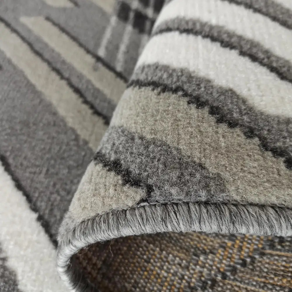 Tepe Lara teppe 160 x 220 cm, nærbilde av stripet mønster og strukturert kant med bøyd hjørne.