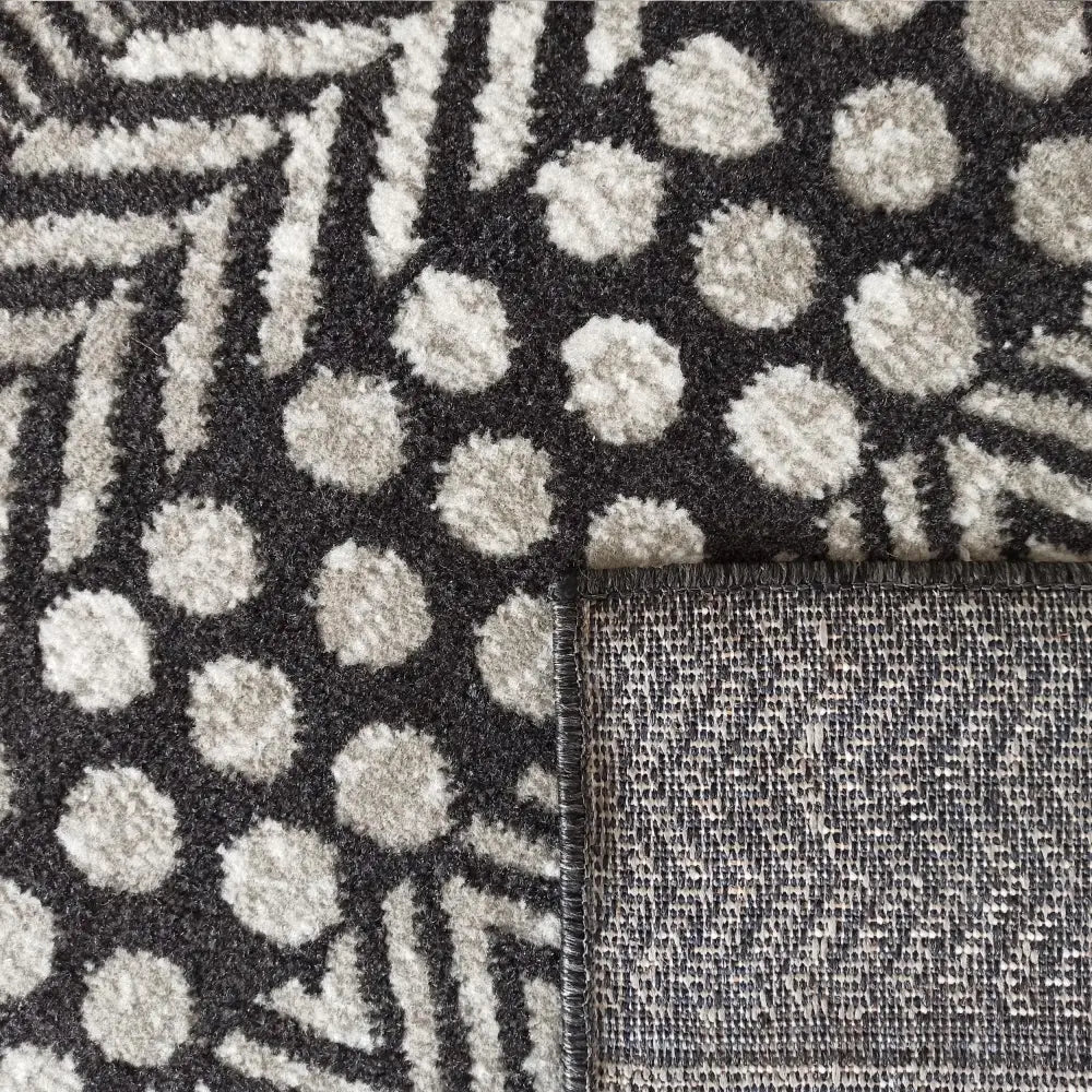 Tepe Lara-teppe 160 x 220 cm, nærbilde som viser lyse prikker, linjemønstre og søm på hjørnet.