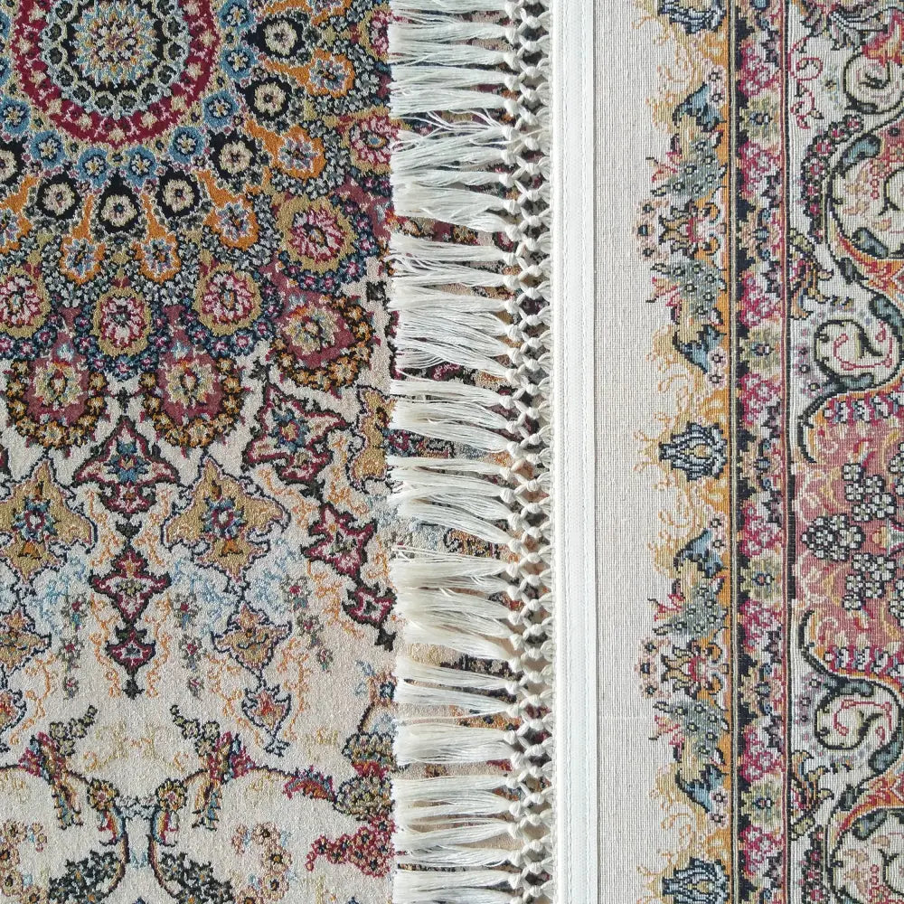 Tepe Luksuriøs Pers 02 Rose, nærbilde av hjørne med frynser og orientalsk mønster i rødt og blått.