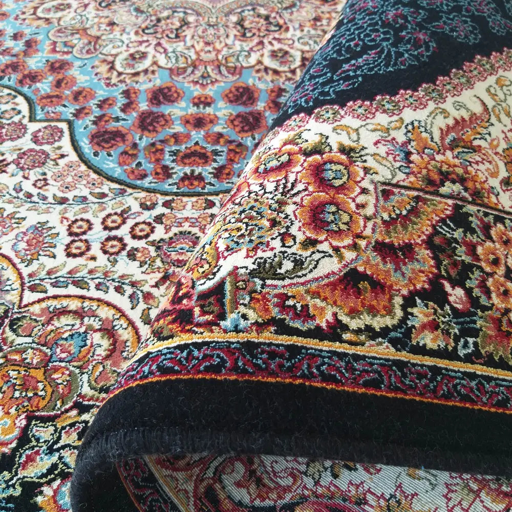 Tepe Luksuriøs Pers 04 Navy, nærbilde av blått orientalsk teppe bøyd for å vise tykkelse og tekstur.