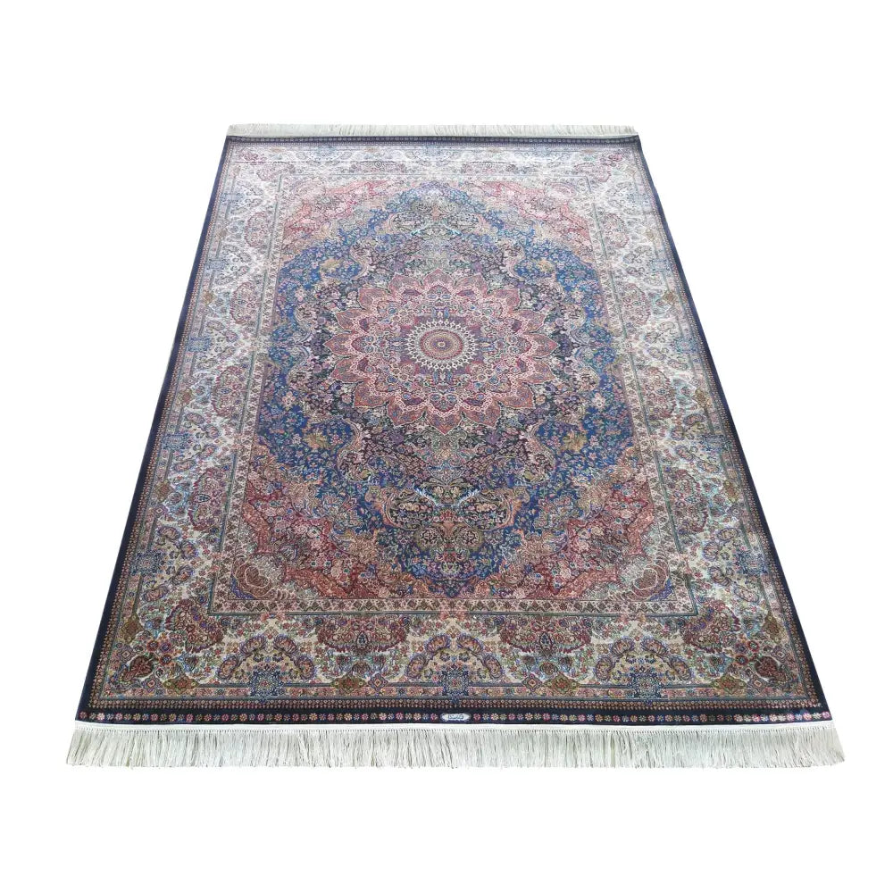 Tepe Luksuriøs Qum Silk teppe 160x230 cm, blått med orientalske mønstre og hvite frynser sett skrått ovenfra.