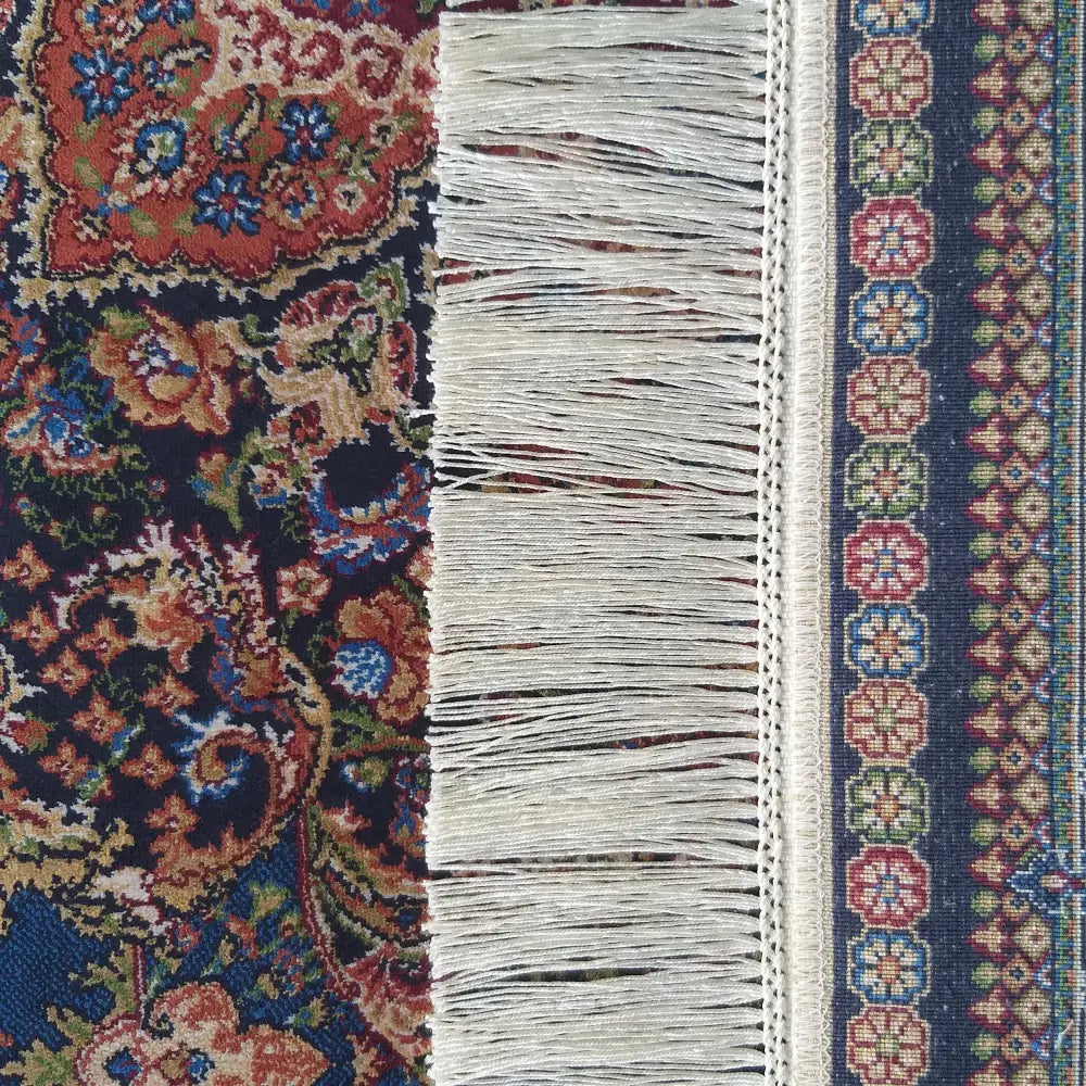 Tepe Luksuriøs Qum Silk teppe, detaljert nærbilde av blått og rødt blomster- og bordermønster med hvite frynser.