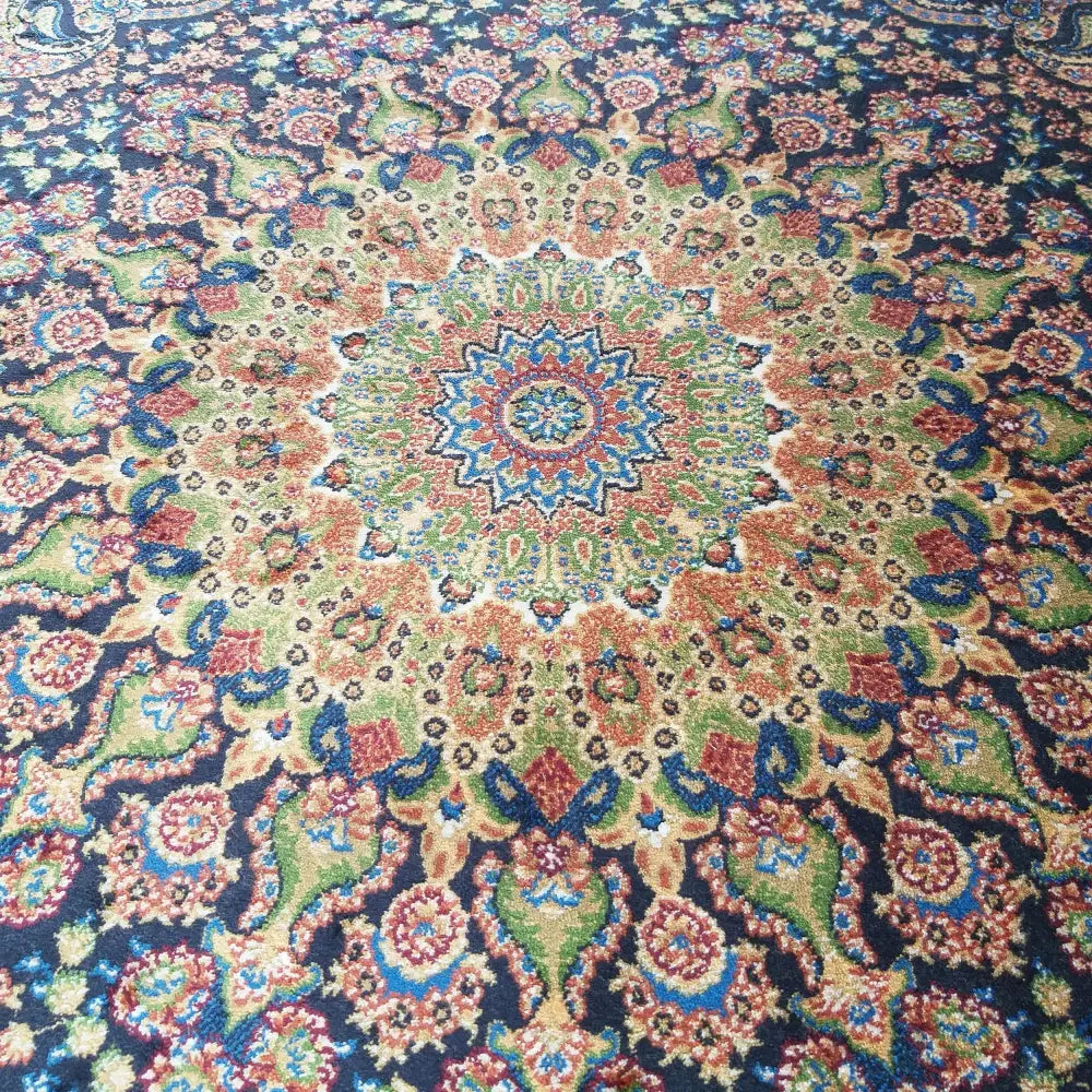 Tepe Luksuriøs Qum Silk-teppe, nærbilde av blått orientalsk mønster med dekorativ rosett og fargerike detaljer.