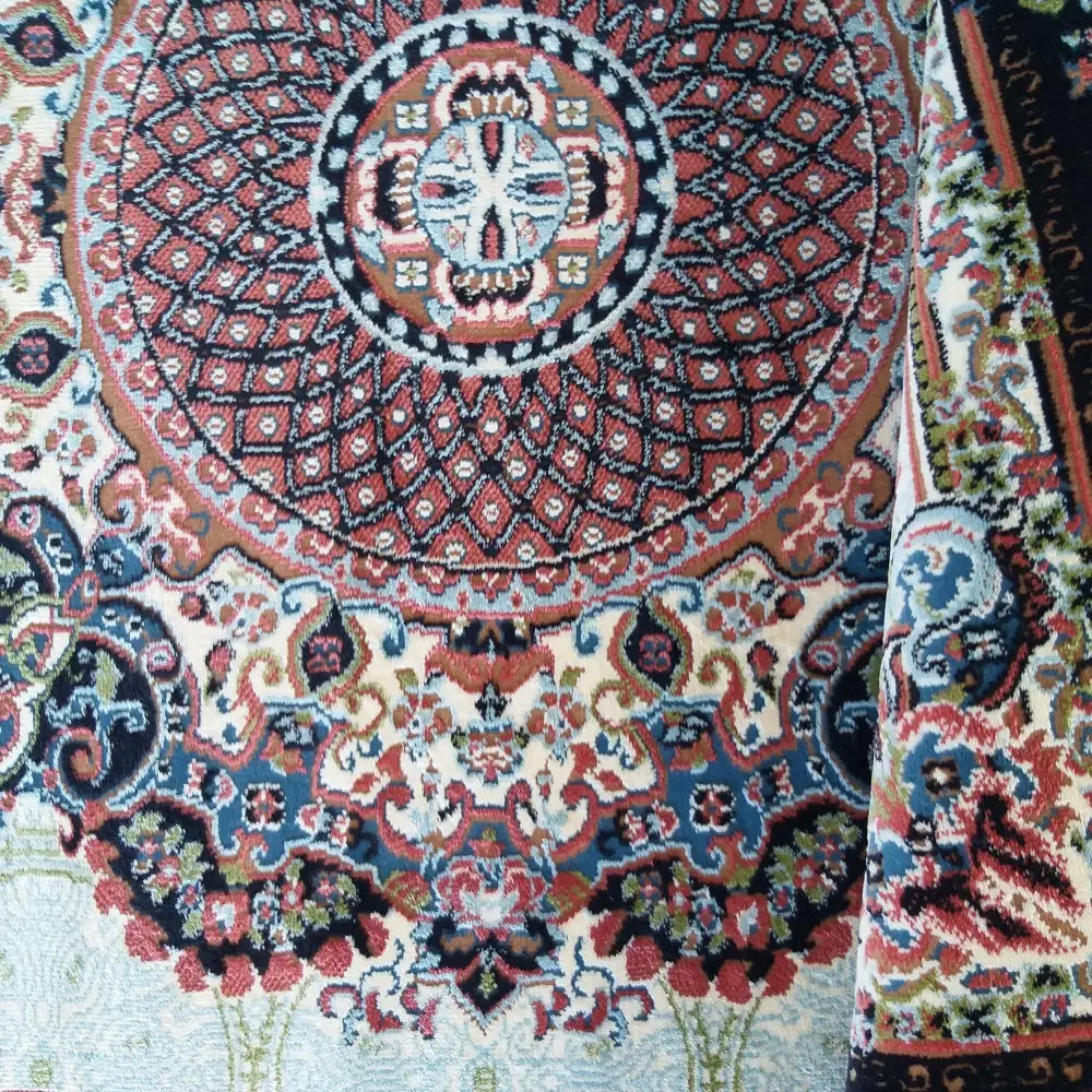 Tepe LUKSUS Irani teppe, nærbilde av hjørnet med brett, viser detaljerte røde og blå orientalske mønstre.