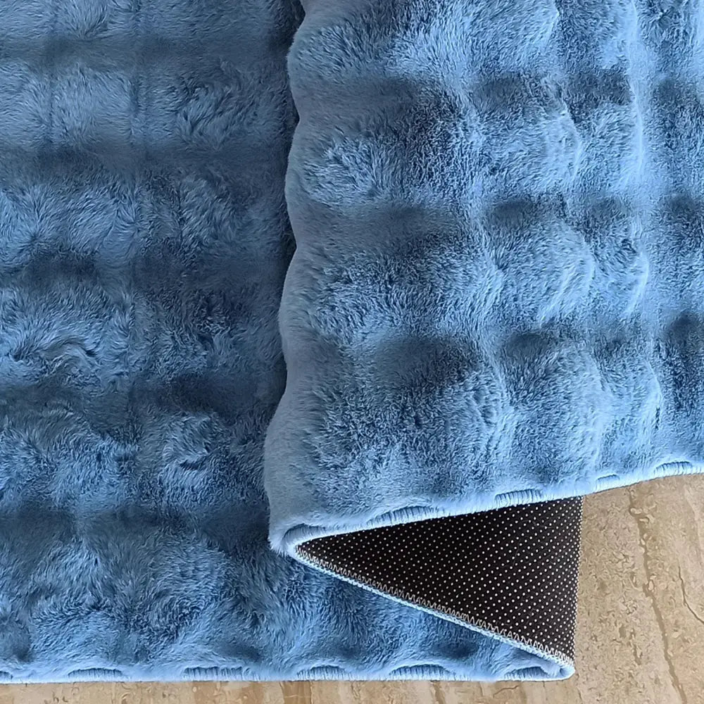 Tepe Merlin 3D lyseblå matte, nærbilde av rutete tekstur og sort antiskli-underdel med hvite prikker på lyst gulv.