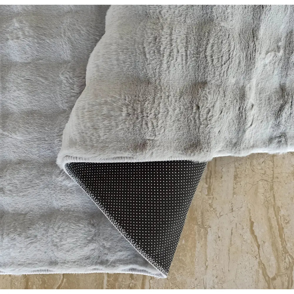 Tepe Merlin 3D teppe i lys grå plysj, detalj med oppbrettet hjørne og mørk grå antiskli-underdel.