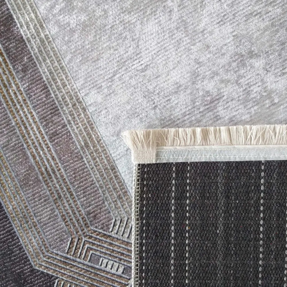 Tepe Moderne EFES, nærbilde av grått teppe med geometrisk mønster og frynset kant samt beige underside.