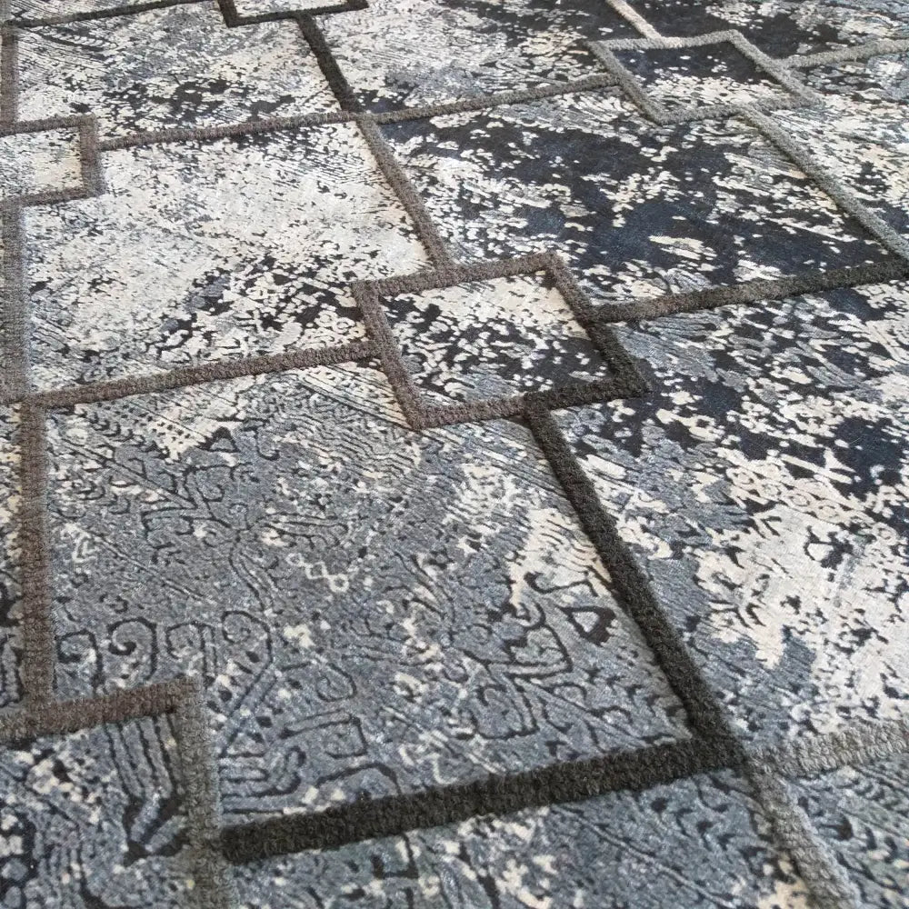 Tepe Moderne Hypnotik 01 teppe, skråvinklet bilde som fremhever rutemønster, struktur og fargevariasjon.