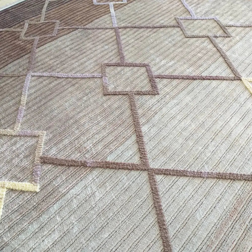 Tepe Moderne Matte Hypnotik 06, nærbilde av strukturert beige og brunt teppe med kvadratiske mønstre.