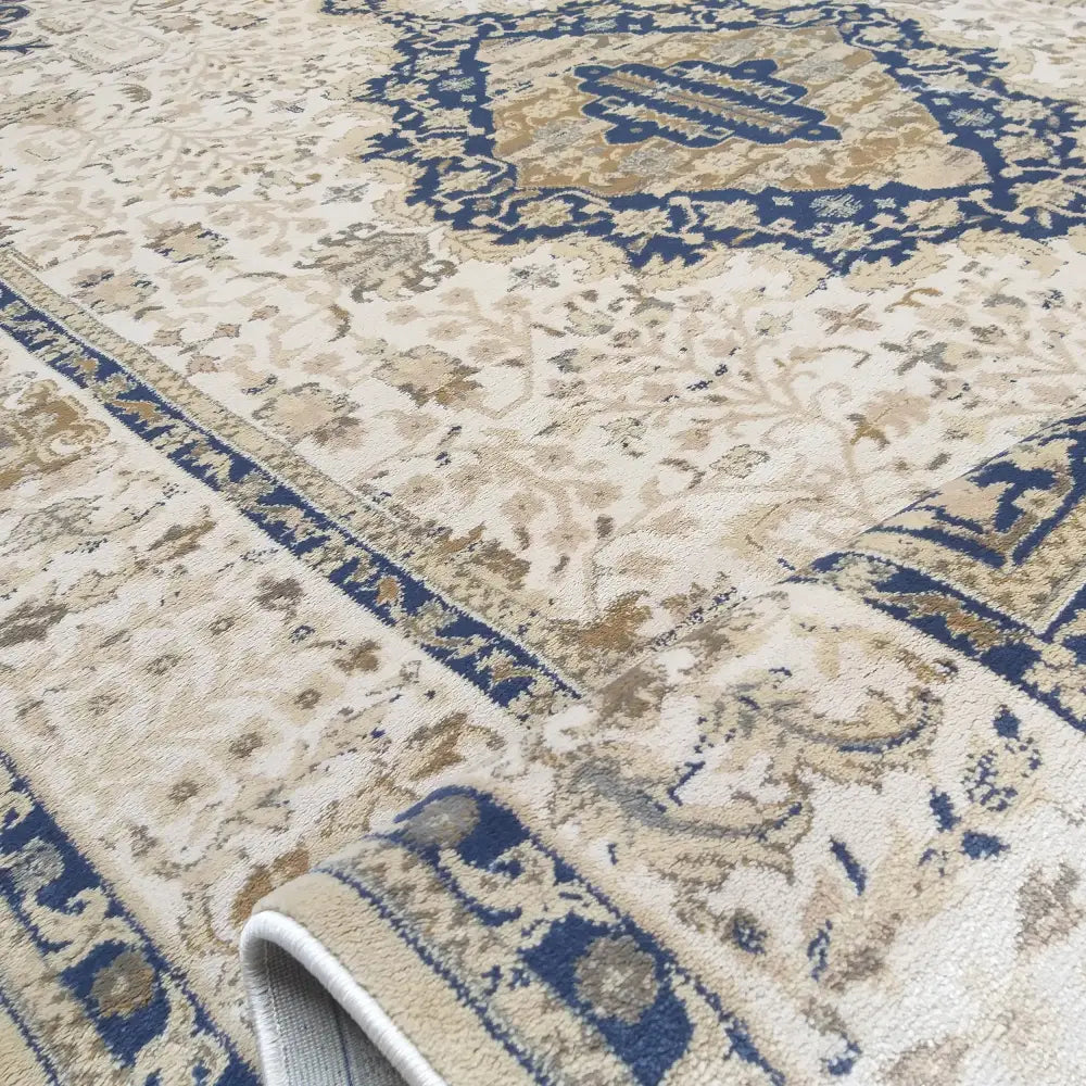 Tepe Moderne Milas Myk Krympe, nærbilde av teppets kant med blå og gull orientalsk bord.