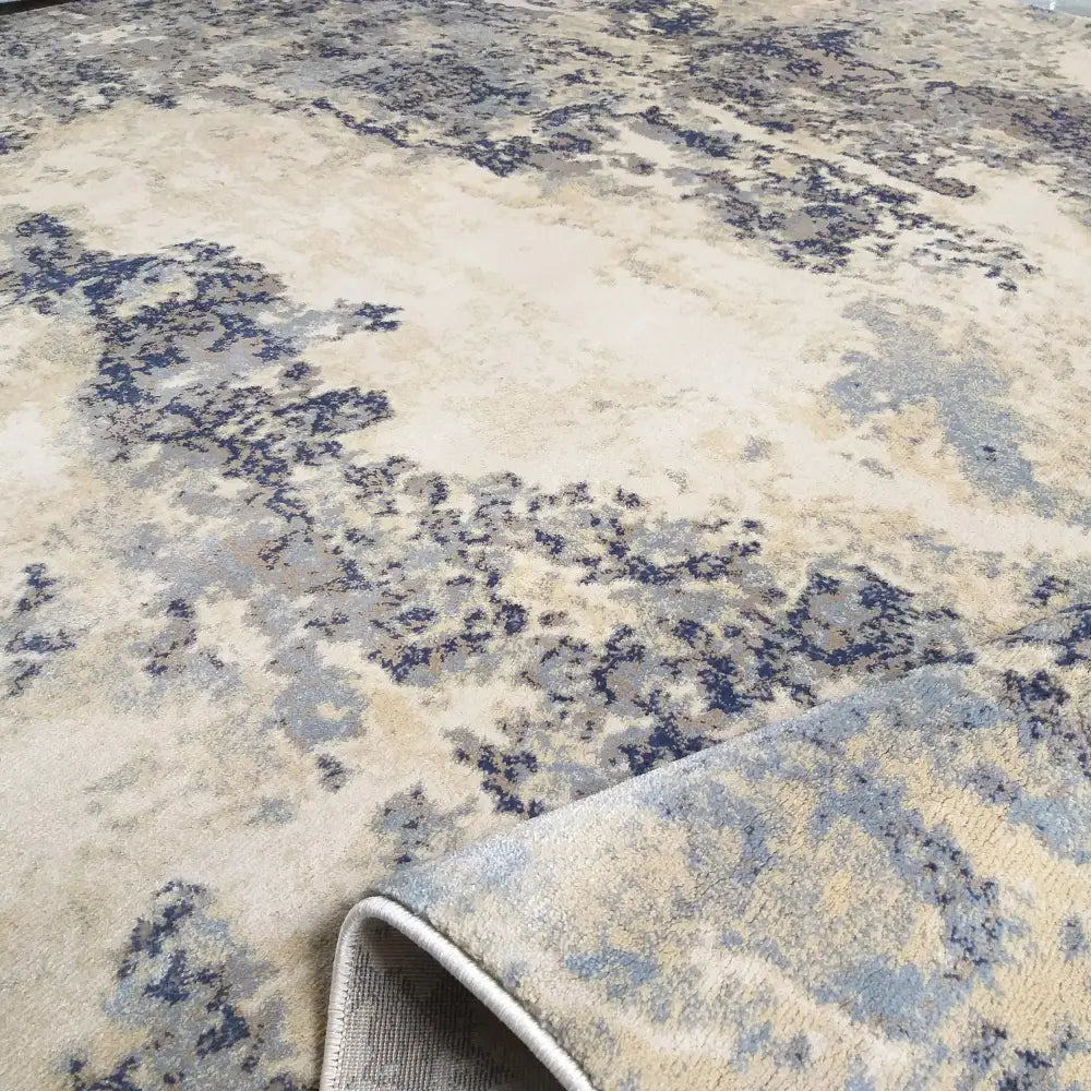 Tepe Moderne Milas-teppe, nærbilde av myk tekstur og bøyd hjørne som viser baksiden og det abstrakte mønsteret.