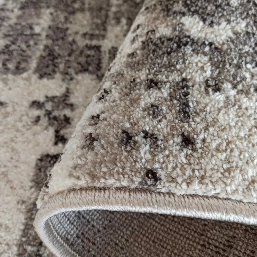 Tepe Moderne Panamero 18 teppe, nærbilde av tykk lugg, beige og brune toner, detaljert kant og rullet tekstur.