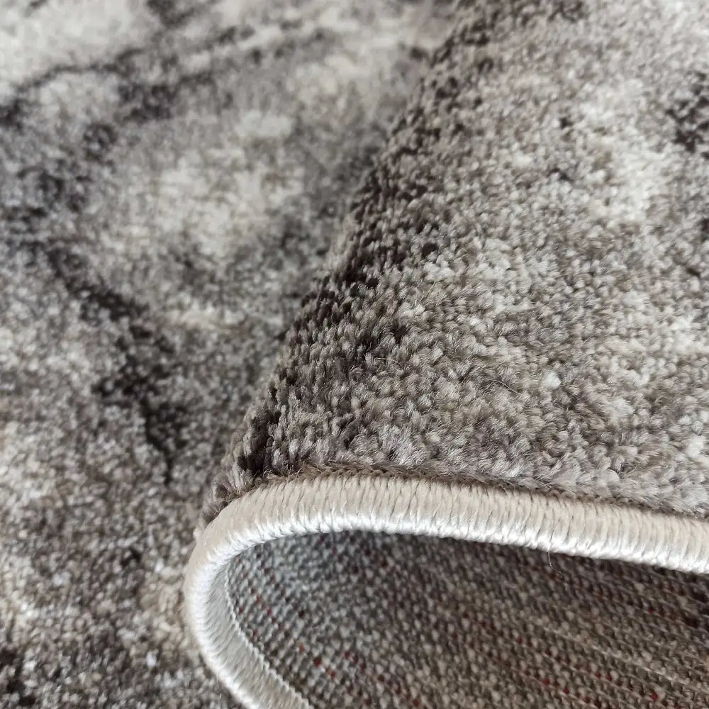 Tepe Moderne Tepp Panamero19 grått, nærbilde av kant med synlig tykkelse, veving og marmorerte detaljer.