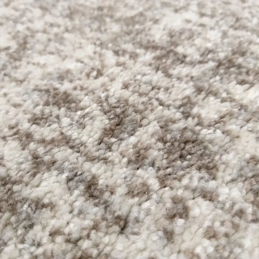 Tepe Moderne Vista teppe, nærbilde som viser myk, tykk fiberstruktur og melert beige-lysebrunt mønster.