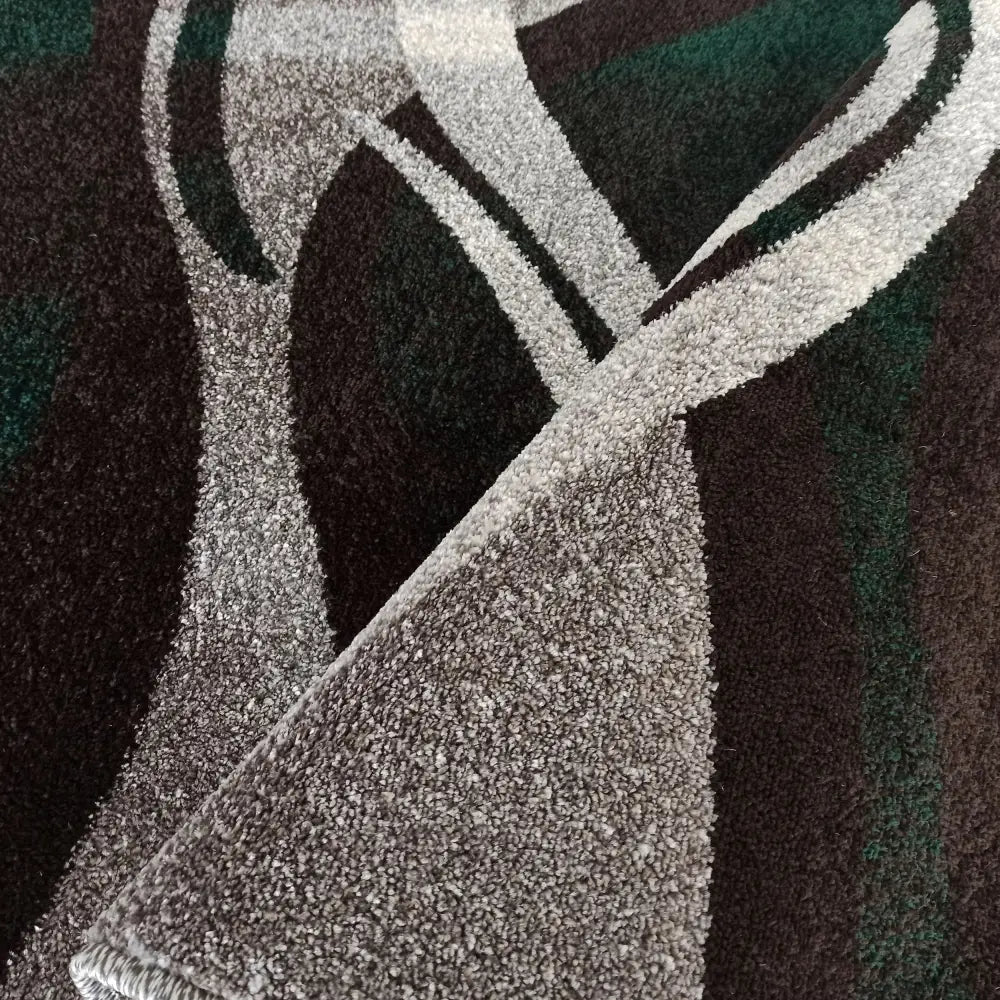 Tepe Otto teppe, nærbilde av tykk, myk tekstur med abstrakt grått og mørkegrønt mønster, oppbrettet hjørne.