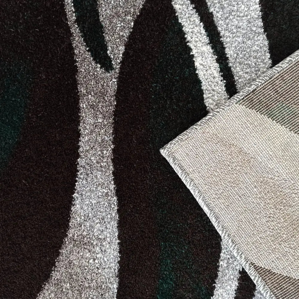 Tepe Otto 01 teppe, nærbilde av abstrakt grått og grønt mønster med oppbrettet hjørne som viser baksiden.
