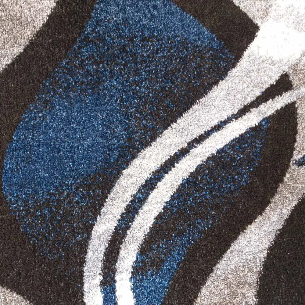 Tepe Otto 01 teppe, nærbilde av blått og grått mønster med buede linjer og myk, luggaktig tekstur.